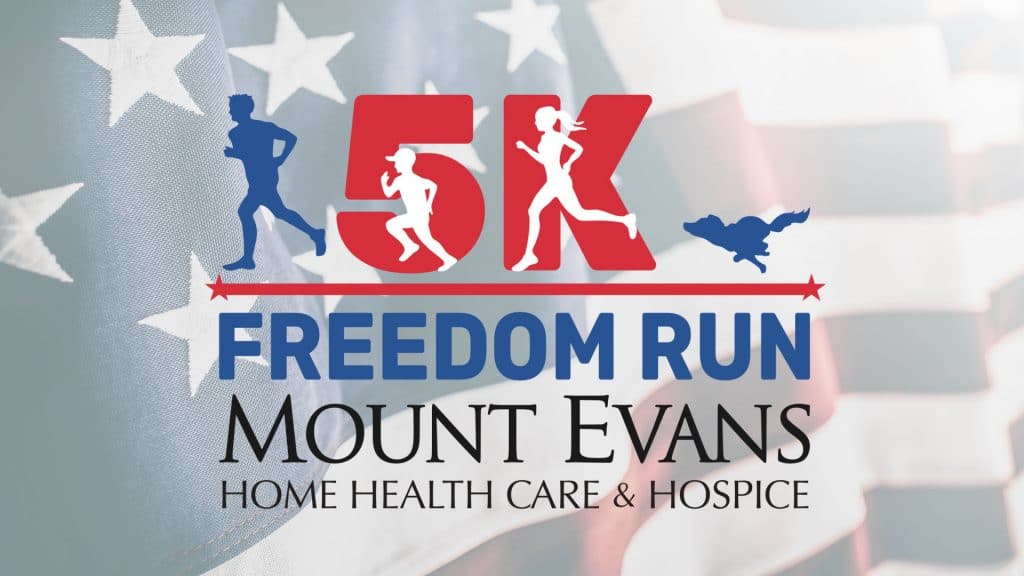 Mount Evans' Freedom Run 5k logo superimposed on top of a waving American flag